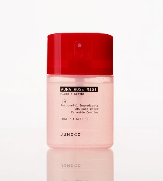 Pink bottle of Junoco Aura Rose Mist with red cap on a white background