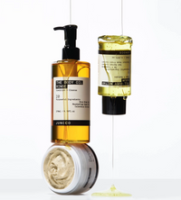Three skincare products hanging against a white background: Shower Oil, Body Serum and Buffing Butter Scrub